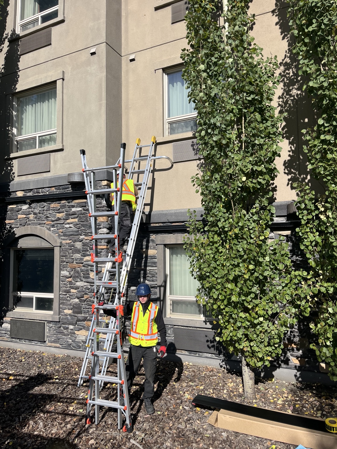 Re-Gutter crew in high-visibility vests working at a hotel property